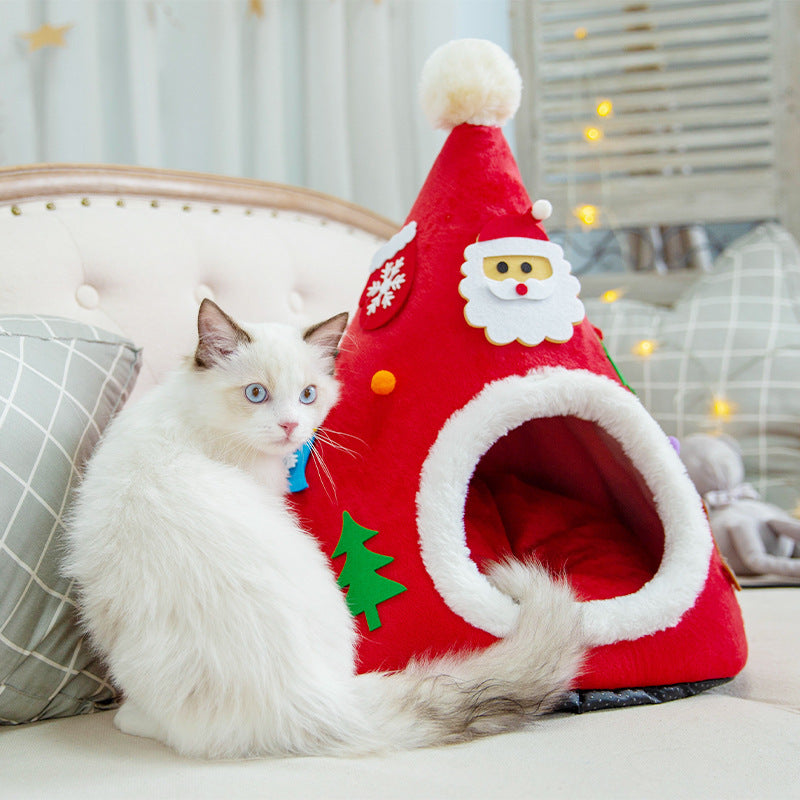 Cat in a red Santa hat shaped cat bed next to a green tree version