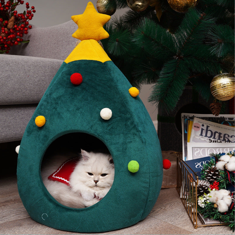 Cat sitting inside a green Christmas tree shaped cat bed