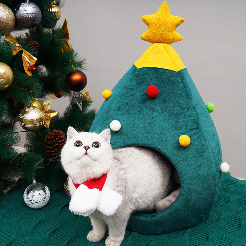 Cat sitting inside a green Christmas tree shaped cat bed
