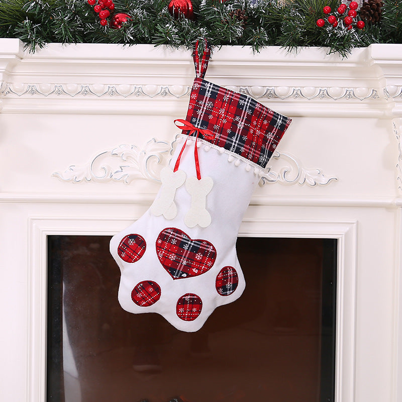Paw-shaped Christmas stockings with tartan tops hanging on a mantelpiece