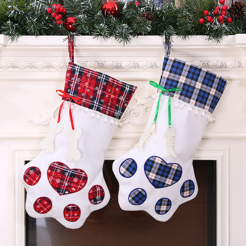 Paw-shaped Christmas stockings with tartan tops hanging on a mantelpiece