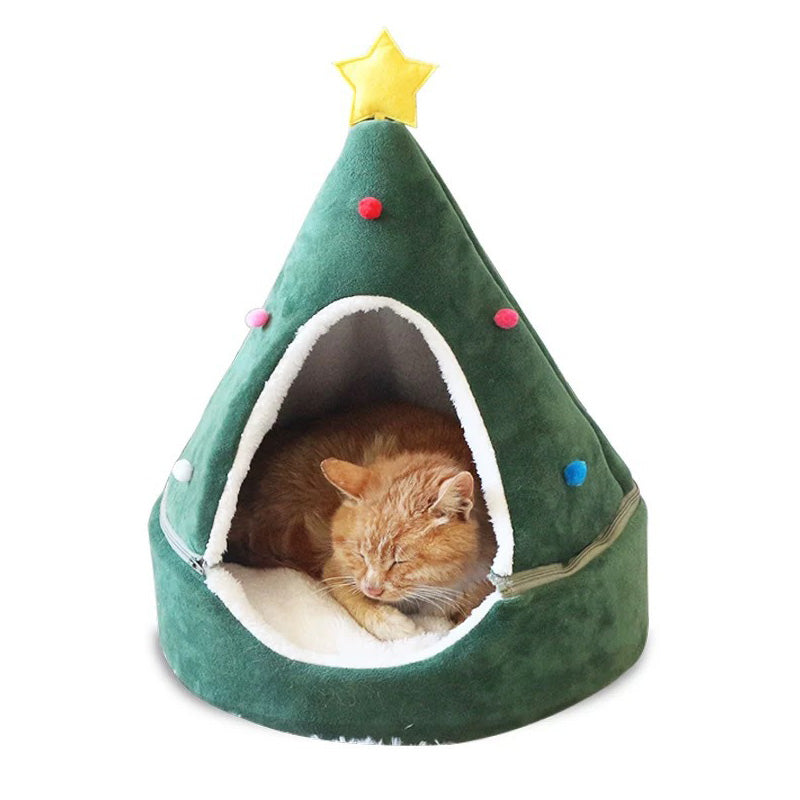 Cat sitting inside a green Christmas tree shaped cat bed