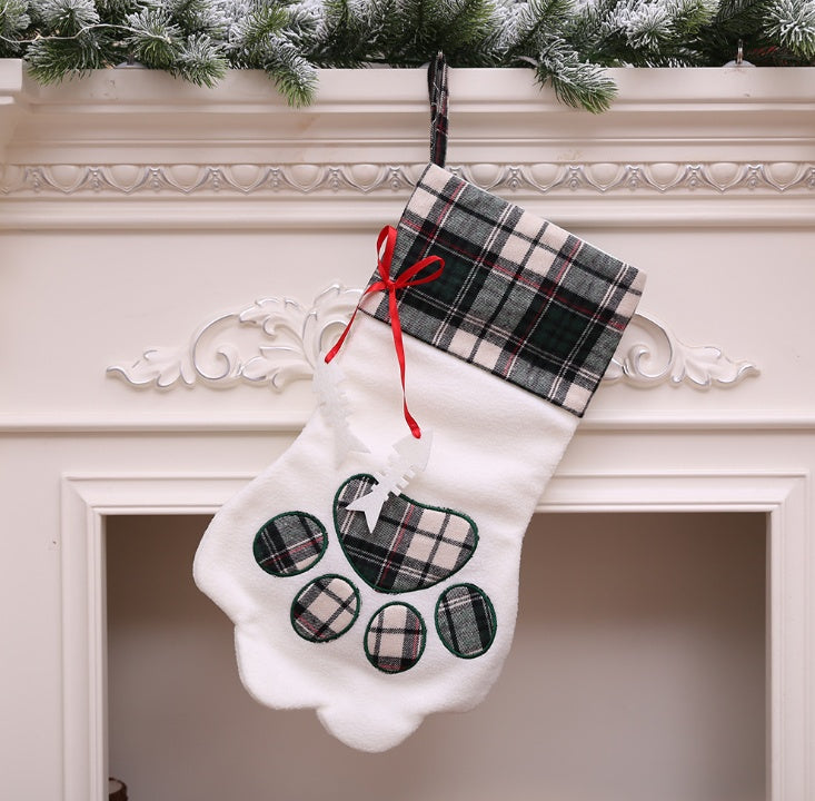 Paw-shaped Christmas stockings with tartan tops hanging on a mantelpiece