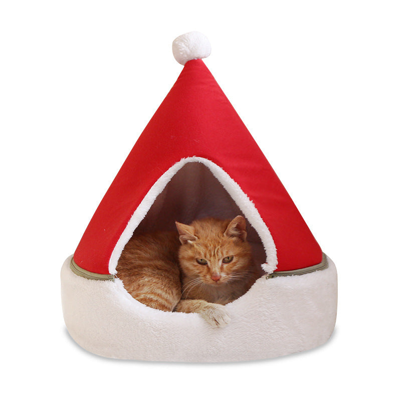 Cat sitting inside a green Christmas tree shaped cat bed